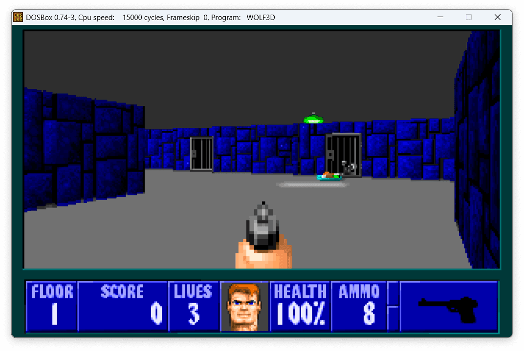 Zrzut ekranu z pierwszego poziomu gry Wolfenstein 3D. Widzimy wyrenderowany trójwymiarowy świat, gdzie widać w perspektywie korytarze i ściany. Na dole ekranu widzimy pasek zdrowia, amunicji i broni.